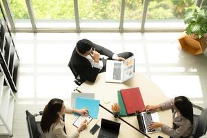 Boss is having a meeting to review investment information with the team in a meeting room with natural light photo