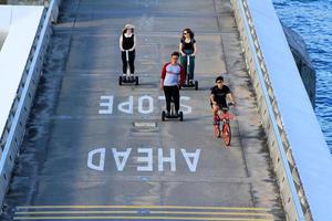 singapur - 22 de febrero de 2021 grupo de personas andan en bicicleta y usan un dispositivo de monociclo en lugar de correr en la calle o carretera en marina bay, singapur. actividad, deporte y ejercicio por la mañana o por la noche. foto