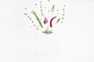 Blank notepad pages with greens herbs and spices photo