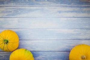 Orange pumpkins on blue wooden background photo