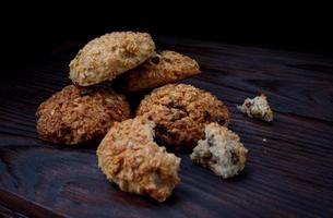 Oatmeal cookies lie on a wooden surface. Rustic oatmeal cookies. Whole and crushed cookies. photo