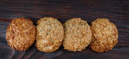 Oatmeal cookies laid out in a row on a wooden board top view. Rustic oatmeal cookies. photo