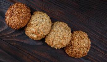 Oatmeal cookies laid out in a row on a wooden board top view. Rustic oatmeal cookies. photo