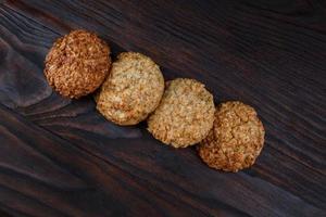 Oatmeal cookies laid out in a row on a wooden board top view. Rustic oatmeal cookies. photo