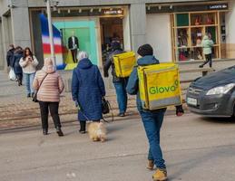 Dnepropetrovsk, Ukraine - 02.09.2022 A delivery service courier with a thermal bag walks through the city. Home food delivery. photo