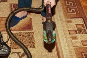 The process of cleaning the carpet with a vacuum cleaner with a water filter. Nozzle for the vacuum cleaner for the formation of cleaning foam assembly photo