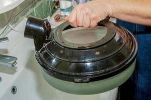 A woman draws clean water into the water tank for a washing vacuum cleaner with a water filter. photo