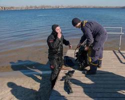 Dnepropetrovsk, Ukraine, Dnieper river - 02.21.2022 Professional diver near the river coastline. Commercial diving. Winter. photo