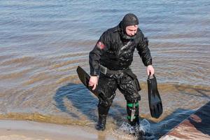 dnepropetrovsk, ucrania, río dnieper - 02.21.2022 buzo profesional cerca de la costa del río. buceo comercial. invierno. foto