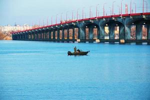 Fishermen on a boat on the river catch fish in autumn. Fishing is a special kind of sport. photo