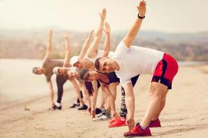 Group Friends Exercising On The Beach photo