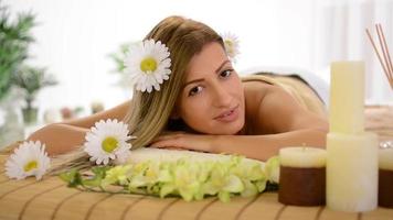 Young woman lying on a towel during a skincare treatment at a spa. video