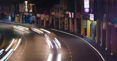 video de lapso de tiempo iluminado de la carretera de la calle en el área del distrito de penang de la antigua arquitectura colonial de la casa adosada del centro con algo de tráfico en la noche con exposición prolongada a la luz, centro histórico