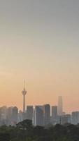 Vista vertical del paisaje de lapso de tiempo del área del distrito del centro de la ciudad de Kuala Lumpur con muchos rascacielos que construyen torres de estilo moderno de gran altura con un hermoso cielo de crepúsculo de la puesta del sol de vainilla video