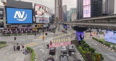 video de lapso de tiempo iluminado de la calle en el área del famoso distrito financiero del centro de negocios de la ciudad con algo de tráfico en kl, fondo de lapso de tiempo del distrito del centro de la ciudad moderna