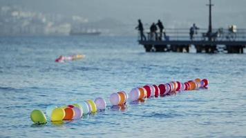 divertente colorato palloncini su il mare acqua e persone pesca silhouette video