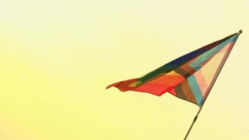 regenbogen-lgbt-flagge flattert auf der stange im hintergrund des sonnenuntergangshimmels. Konzept der Freiheit und Geschlechtervielfalt video