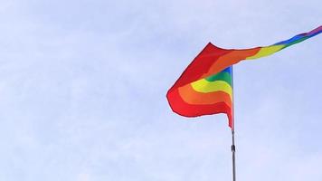 bandera del arco iris lgbt ondeando en el viento sobre un fondo de cielo nublado. concepto de libertad y amor y diversidad de género video