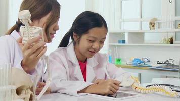 las colegialas asiáticas están estudiando ciencia y tecnología en un laboratorio. los maestros enseñan ciencias a los estudiantes para aprender habilidades de proceso. video