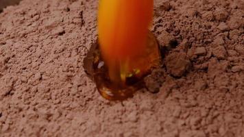 l'œuf de poule tombe au ralenti dans la farine de cacao en gros plan. recette étape par étape pour faire des biscuits au chocolat maison ou un gâteau aux brownies. video