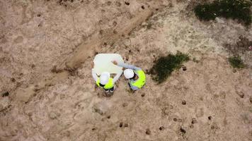 Male and female environmental engineers inspect the forest for the development of the high voltage pole foundation construction site. video