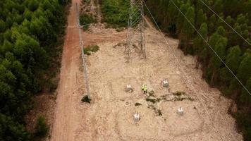 manlig och kvinna miljö- ingenjörer inspektera de skog för de utveckling av de hög Spänning Pol fundament konstruktion webbplats. video