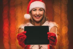 Girl With Santa Hat And Tablet photo