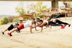 grupo de amigos haciendo ejercicio en la playa foto