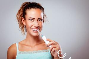 cepillarse los dientes con irrigador dental foto