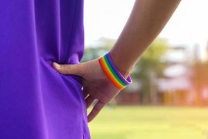 un joven lgbt asiático con muñequeras de arco iris tomados de la mano en la cintura, muestra el símbolo de las personas lgbt y el orgullo transgénero y los movimientos sociales lgbt. foto