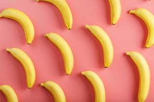 Bright pattern of yellow bananas on a pink background. photo