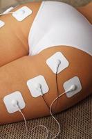 electrodos de mioestimulación en las nalgas y piernas de una mujer en un salón de belleza. foto