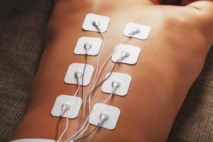 Electrode Stimulating massage of the spine at home. photo