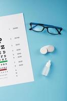 Ophthalmic Accessories Glasses and lenses with an Eye Test Chart for vision correction on a blue background photo