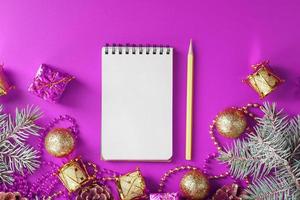 Notepad In festive toys and decorations on a pink purple background. photo