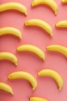 Bright pattern of yellow bananas on a pink background. photo