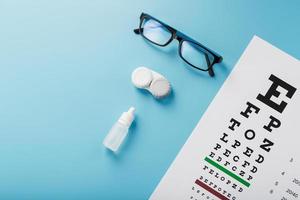 Ophthalmic Accessories Glasses and lenses with an Eye Test Chart for vision correction on a blue background photo