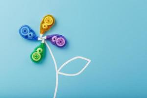 Stationery correction tapes in the shape of a flower of different colors on a blue background. photo