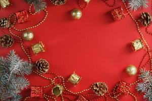 Christmas arrangement of Christmas ornaments and Christmas tree decorations on a red background. photo