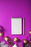 Notepad In festive toys and decorations on a pink purple background. photo