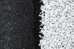 asfalto nuevo negro y fondo plano de grava blanca. foto