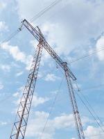 Intermediate steel high-voltage tower against a cloudy sky background. photo