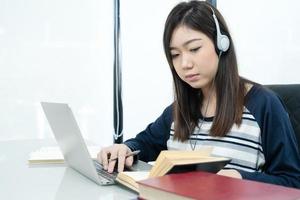 Young female long hair sitting in living room and learning online photo