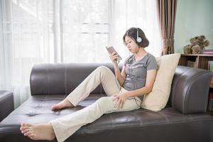 mujer joven escuchando música desde el teléfono móvil foto