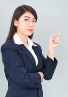 Asian businesswoman in suit with finger pointing up photo