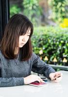 woman sitting sholding credit card and passport on deck in home office photo