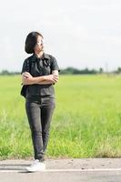 Woman with backpack hitchhiking along a road photo