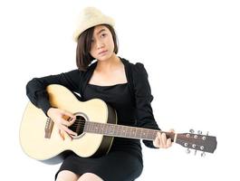 Woman sitting and playing guitar guitar folk song in her hand photo