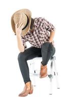 Young woman in a cowboy hat and plaid shirt with hand on her hat photo