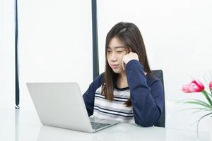 Young female student  sitting in living room and learning online photo